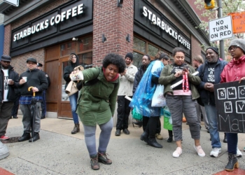 Protestors in front of Starbucks says "too little, too late"